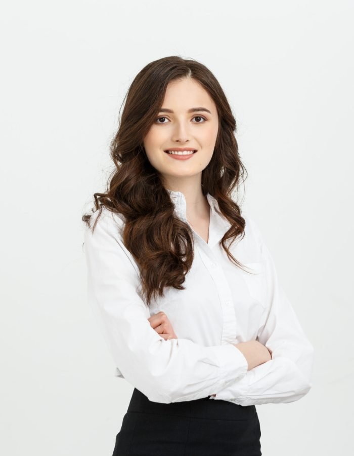 Business Concept: Portrait confident young businesswoman keeping arms crossed and looking at camera while standing against grey background.